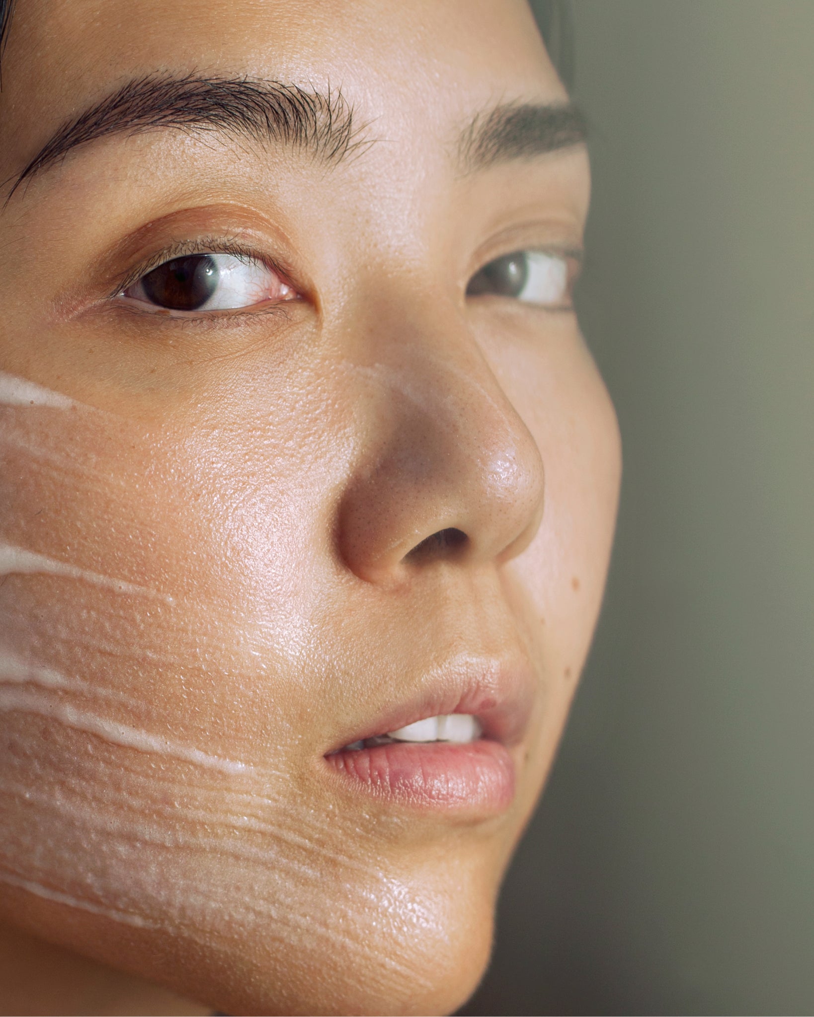 Model wearing MÁDARA Organic Skincare aha peel face mask SM2101 17 face mask on skin; close-up portrait shows natural application results.