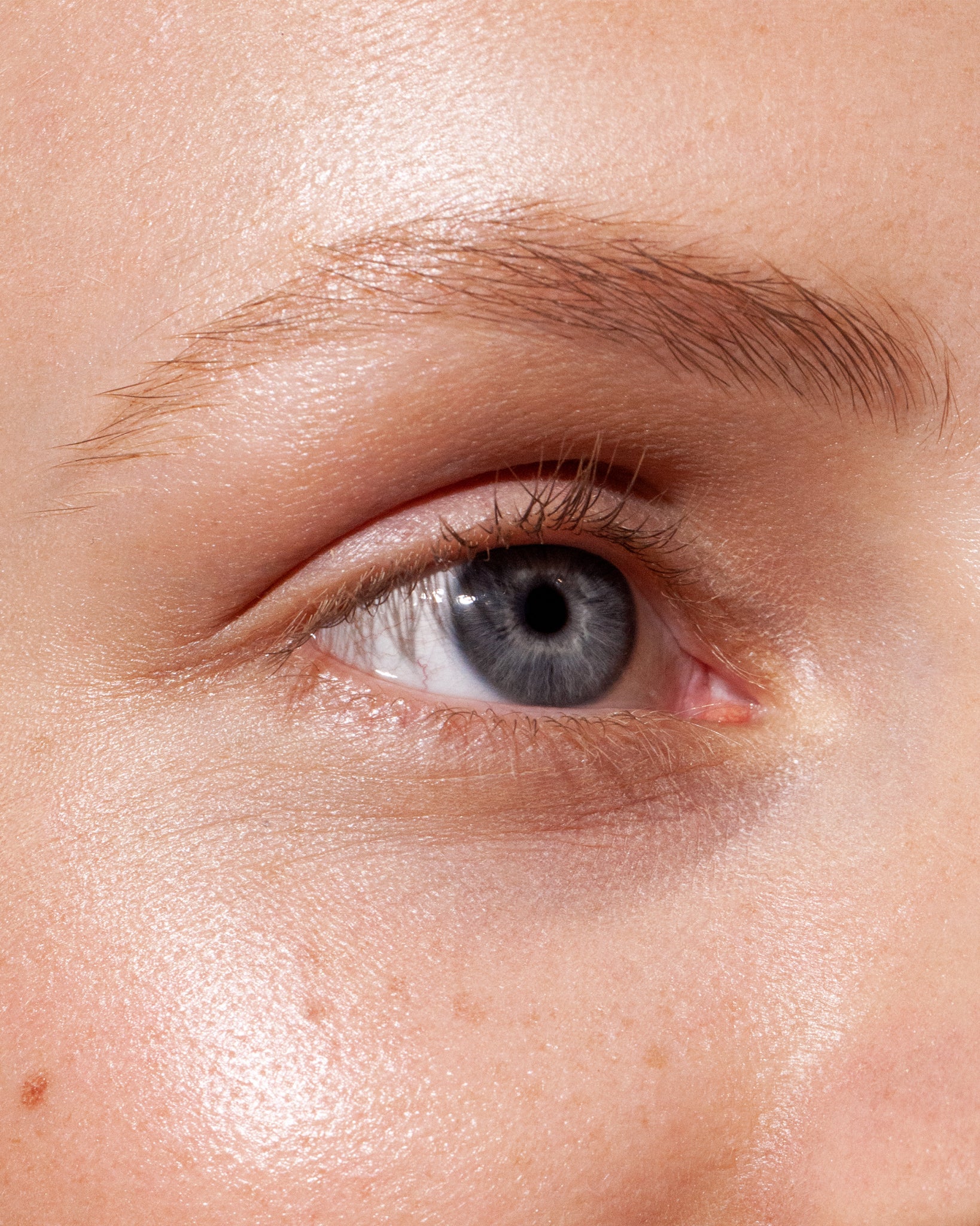 Model wearing MÁDARA Organic Skincare brow and lash booster smoky blonde on A6702 on skin; close-up portrait shows natural application results.