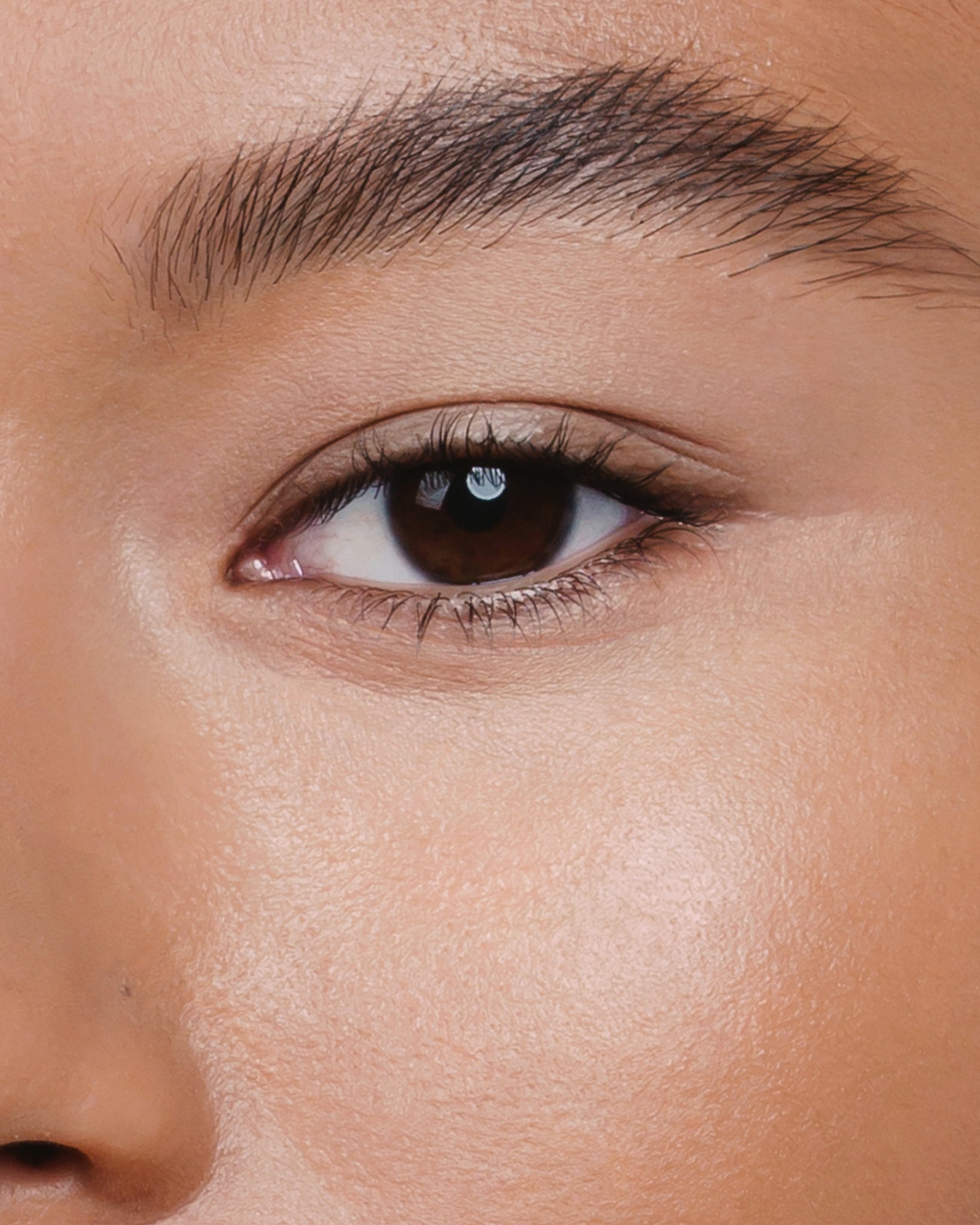 Model wearing MÁDARA Organic Skincare the concealer almond on A6103 concealer on skin; close-up portrait shows natural application results.