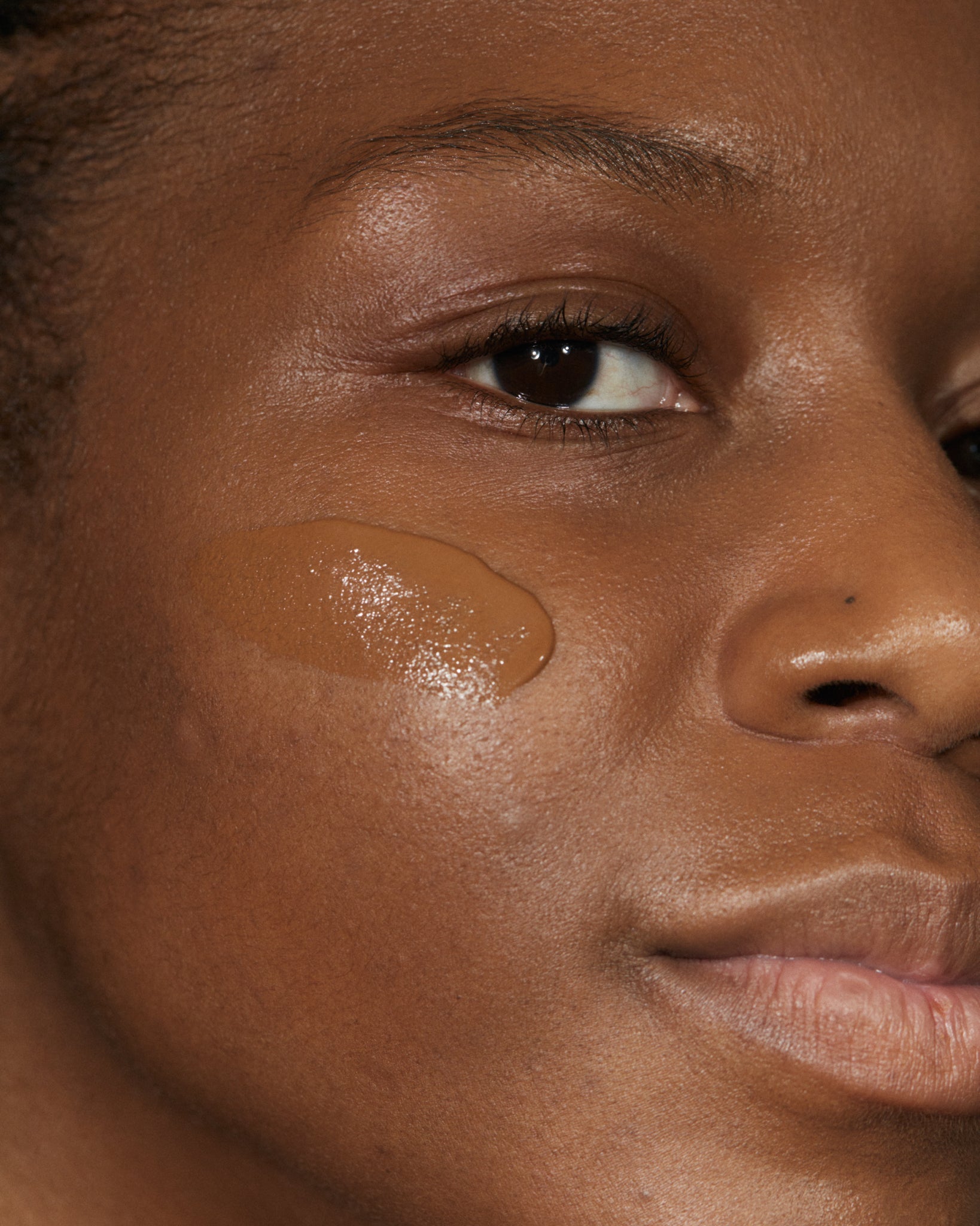 Model wearing MÁDARA Organic Skincare skinonym foundation umber on A6096 foundation on skin; close-up portrait shows natural application results.